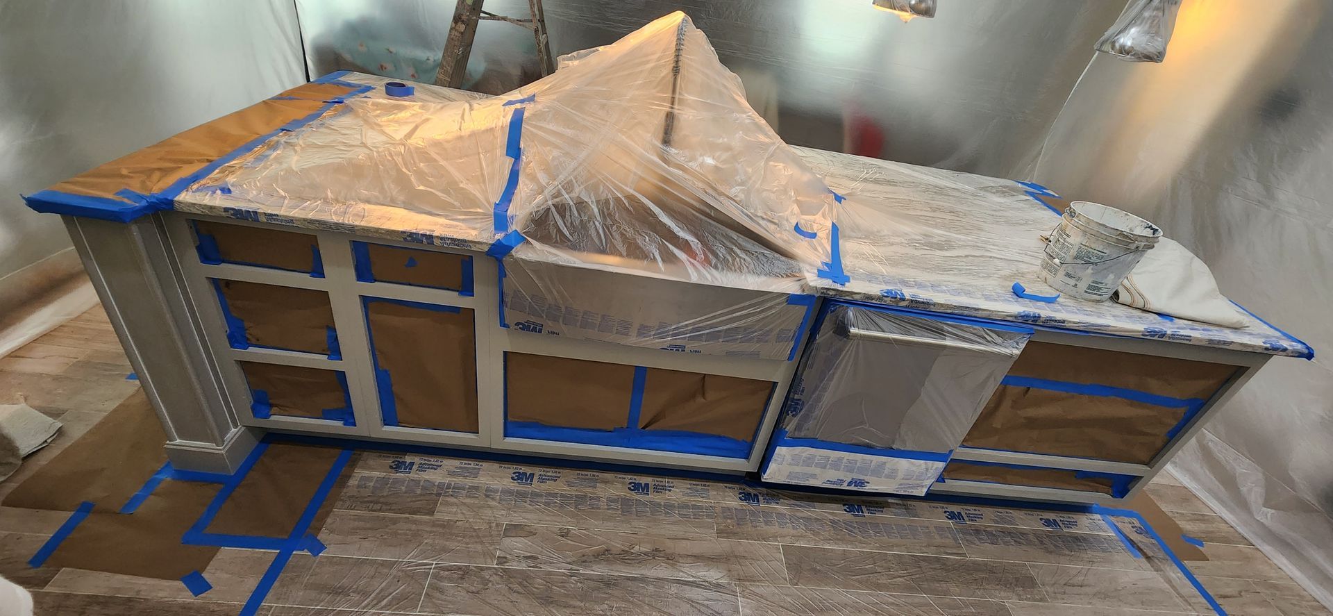 The backyard of a house with a covered patio and a large lawn.