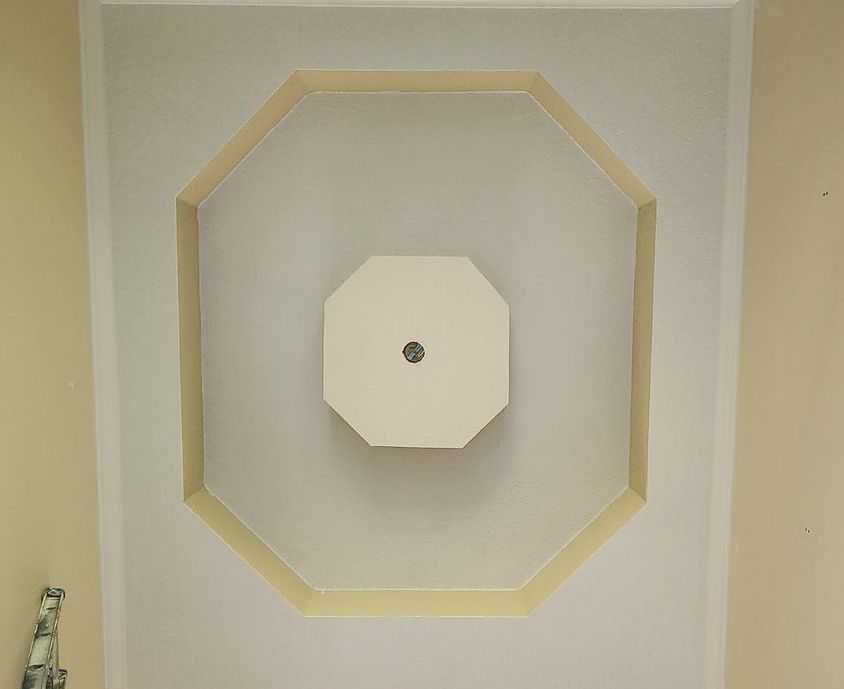 A ceiling with a square in the middle of it.