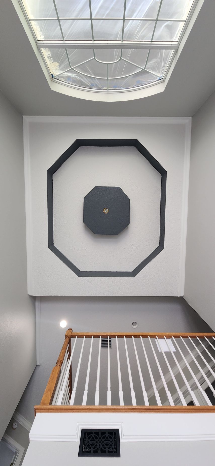 A house is being painted white in a backyard.