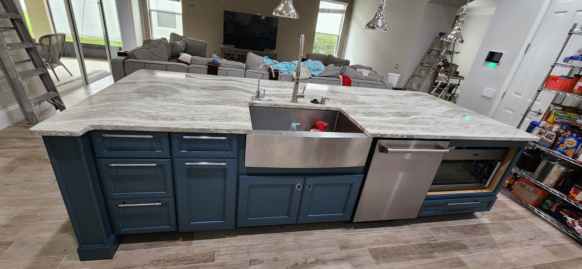 The back of a house with a covered porch and a white fence.