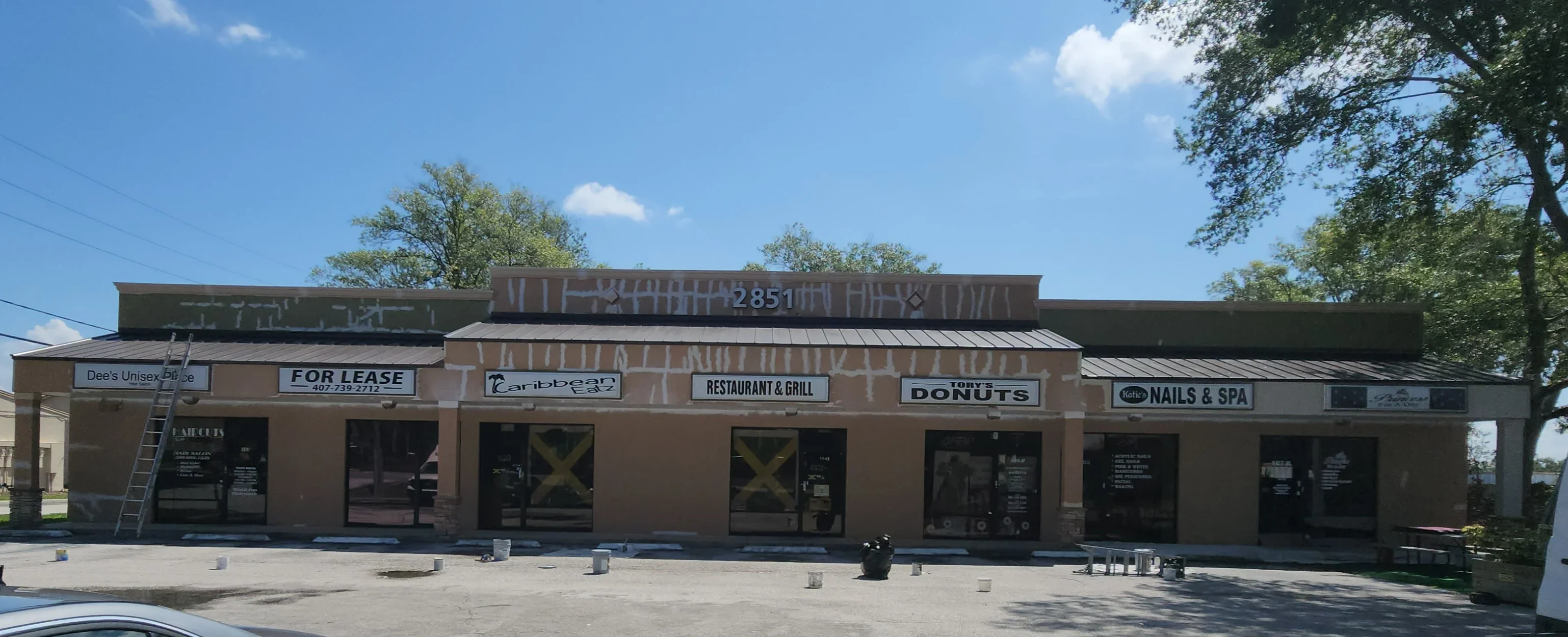Commercial brick storefront with masked windows and doors, metal roof, preparation for painting