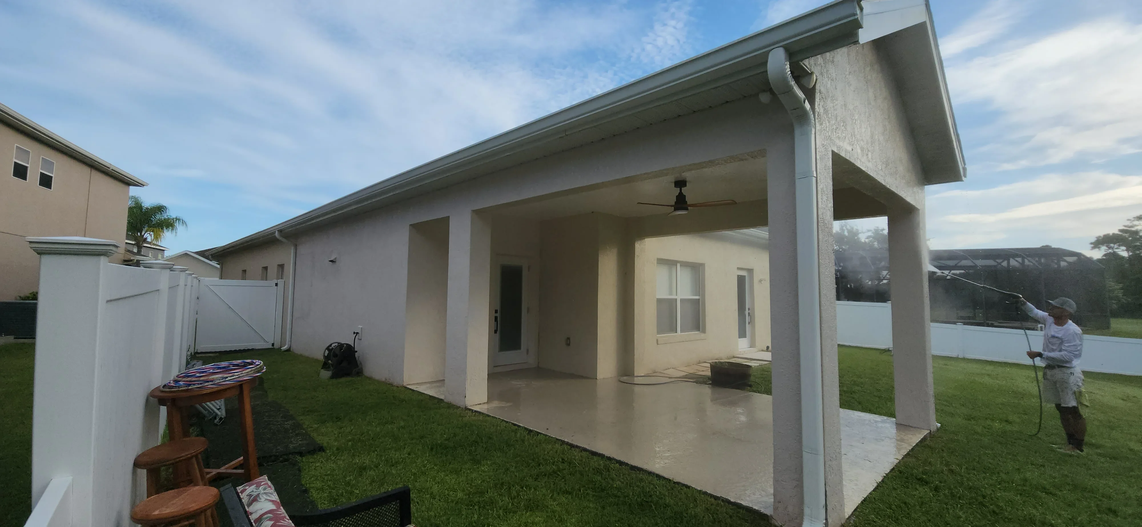 Cream and white stucco exterior with painted columns and covered patio area