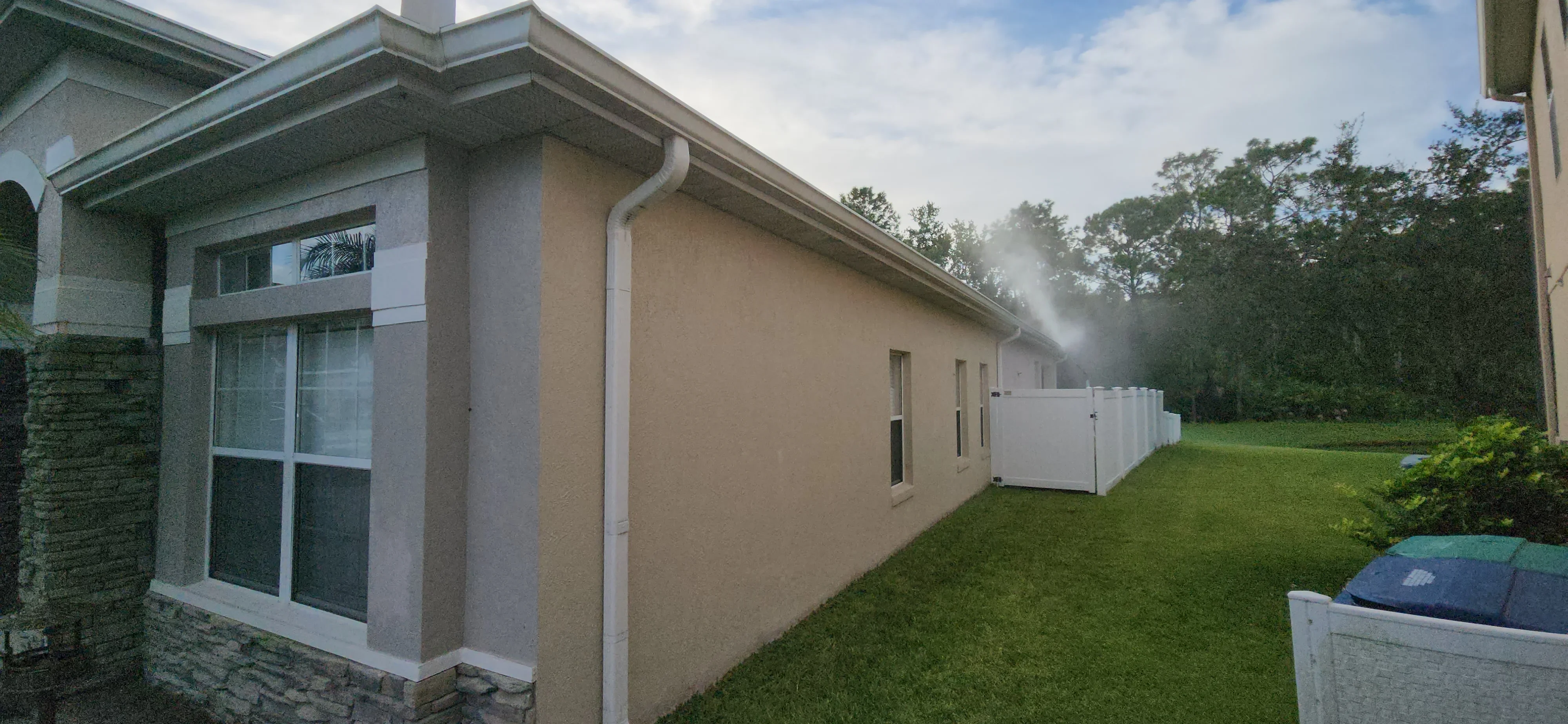 Exterior house with beige stucco walls, white trim, and painted window frames