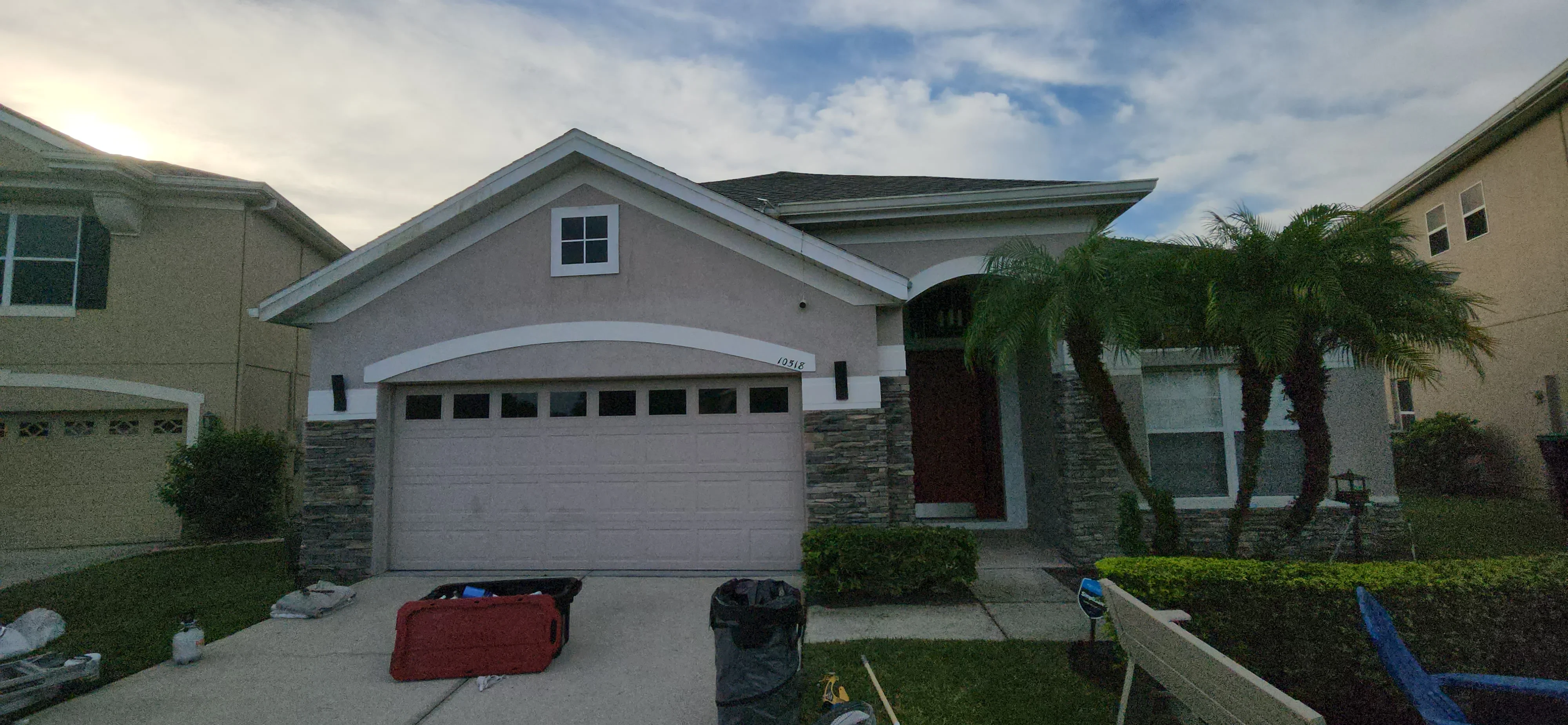 Stucco house exterior with painted garage door and white trim accents