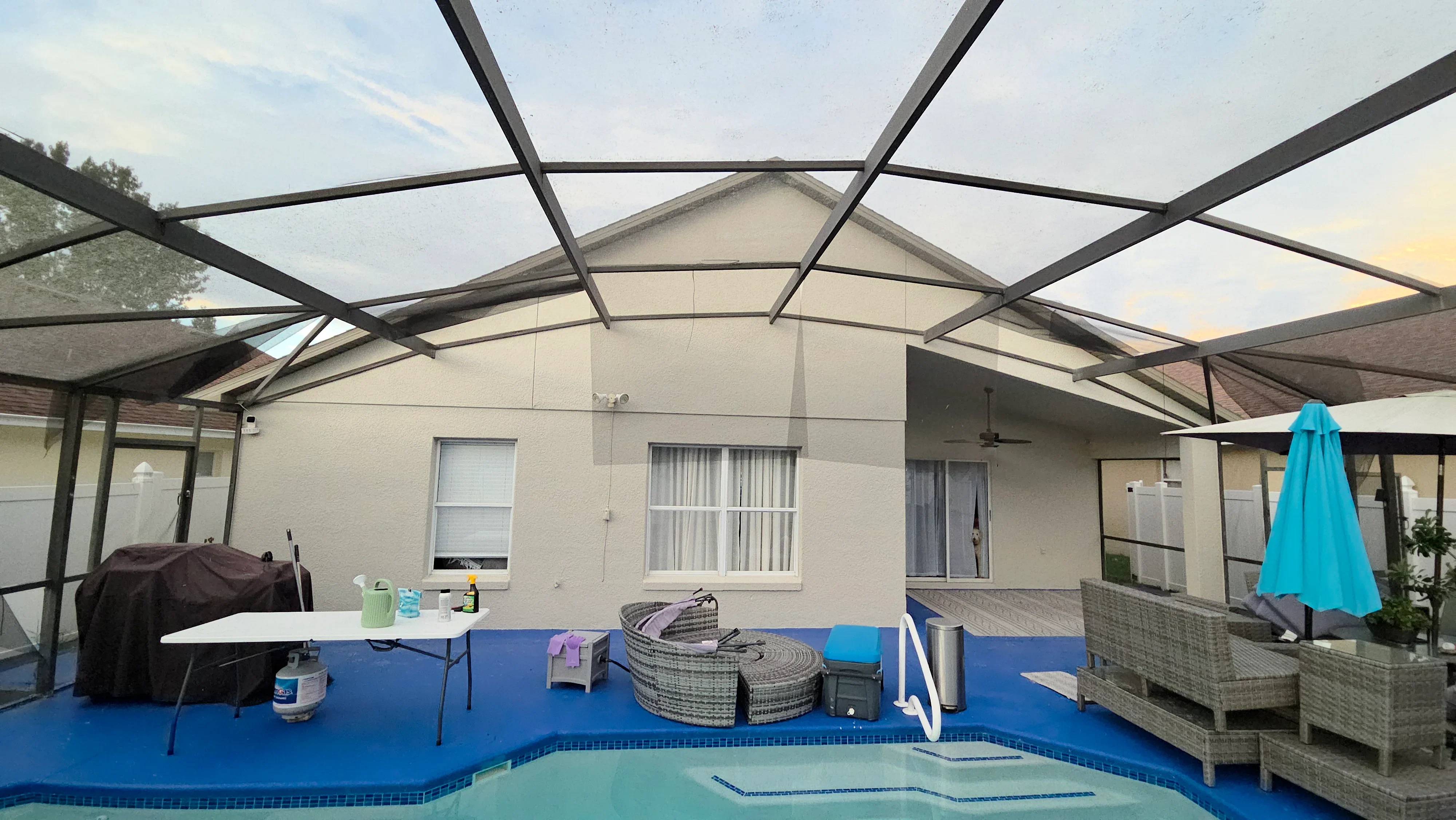 Blue pool deck coating with painted aluminum pergola frame and white fascia panels