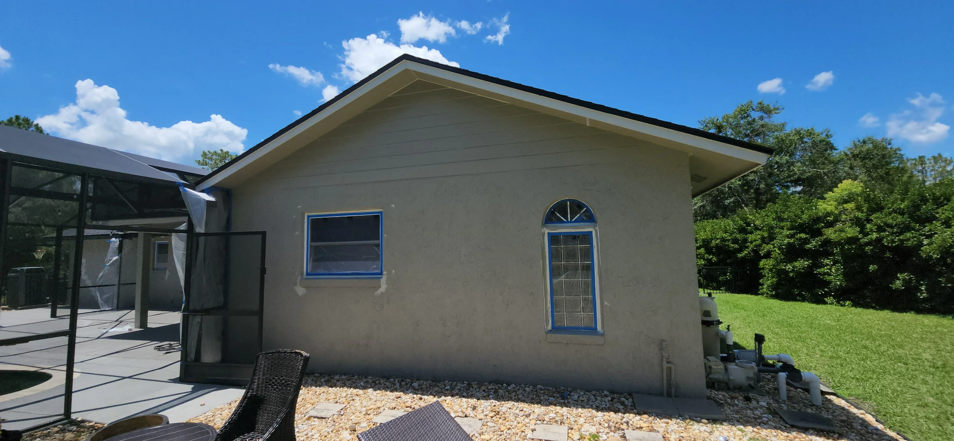 Stucco exterior house with blue-trimmed windows and doors, freshly painted