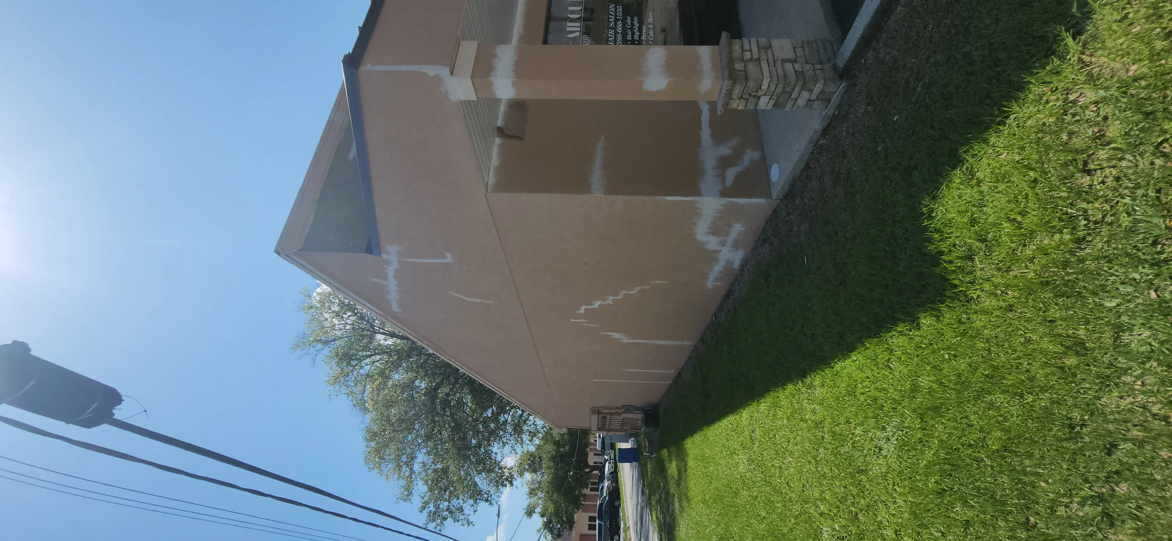 Two-story house exterior with freshly painted brown siding and white trim