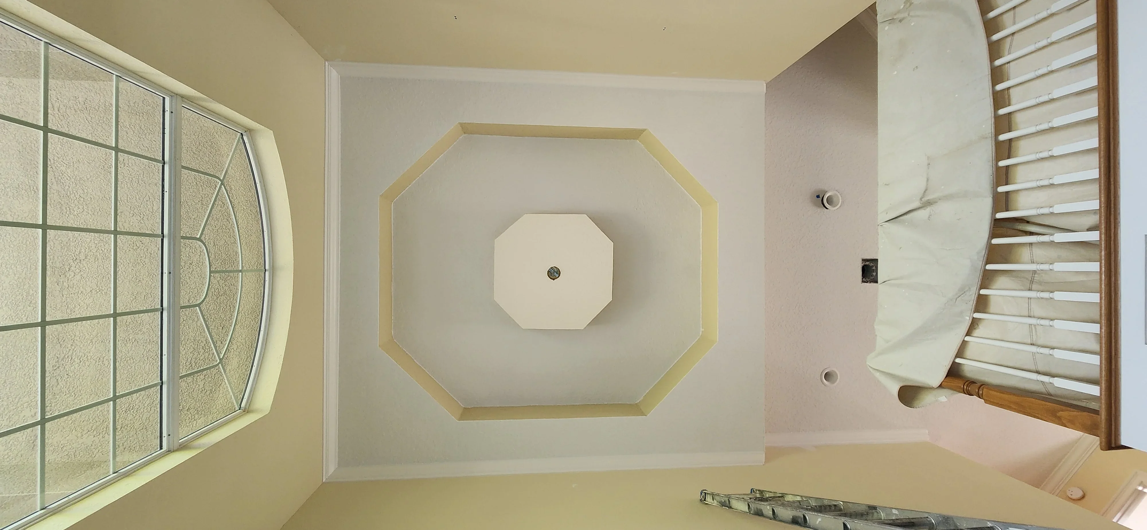 Octagonal drywall ceiling feature with gold trim and recessed lighting in progress