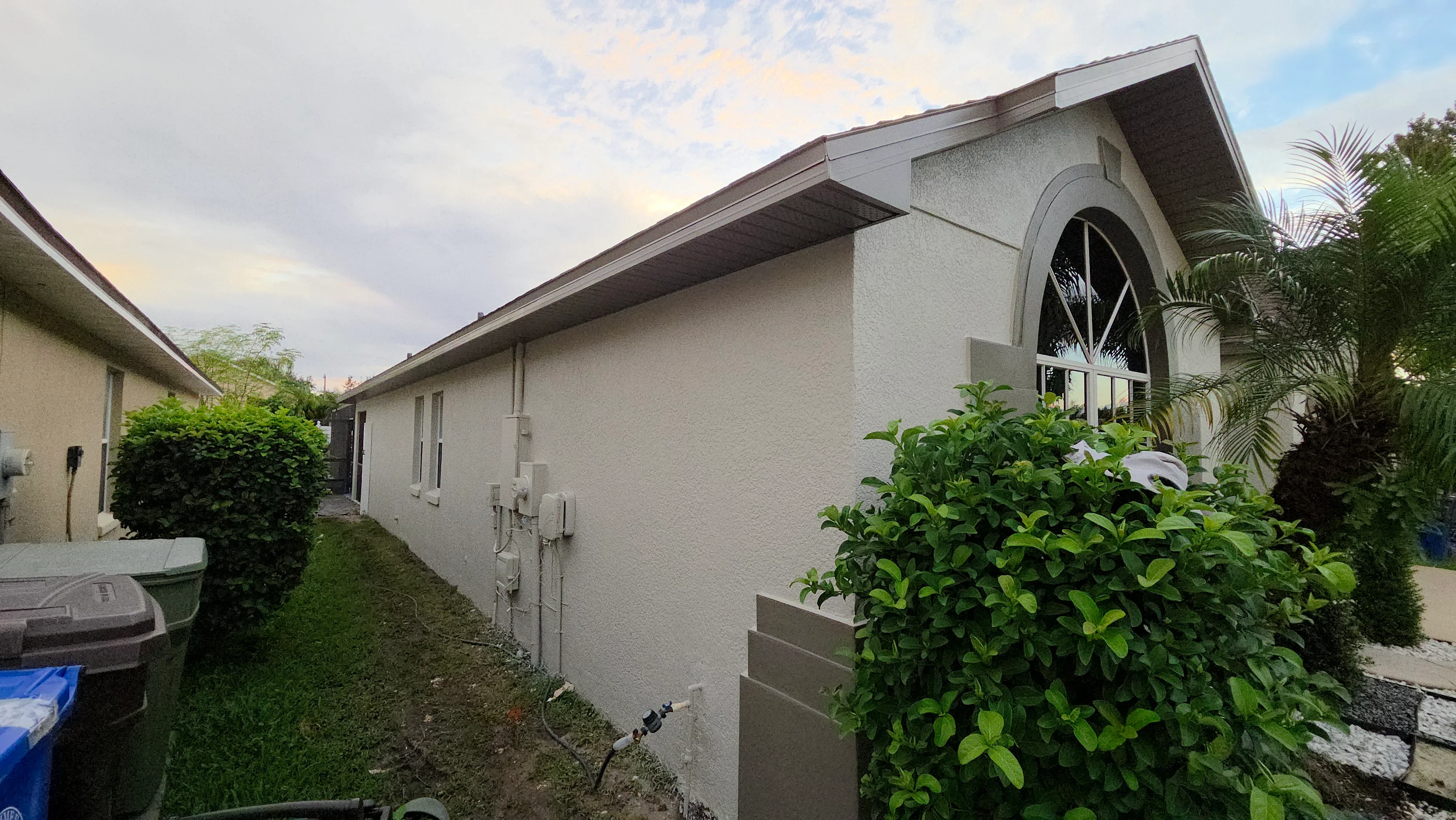 White stucco exterior house with painted walls, soffit, and fascia trim