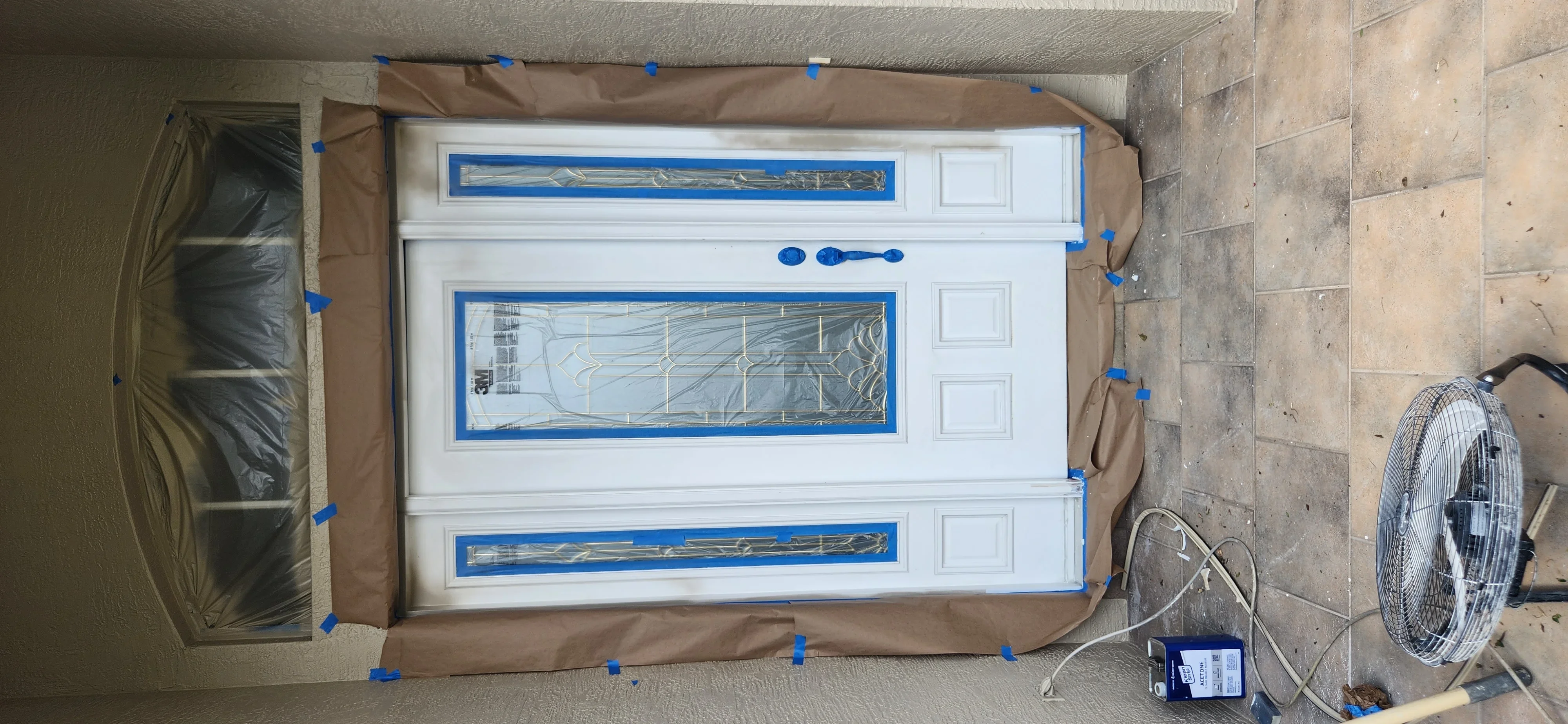 White garage door with glass panels taped for protection during installation