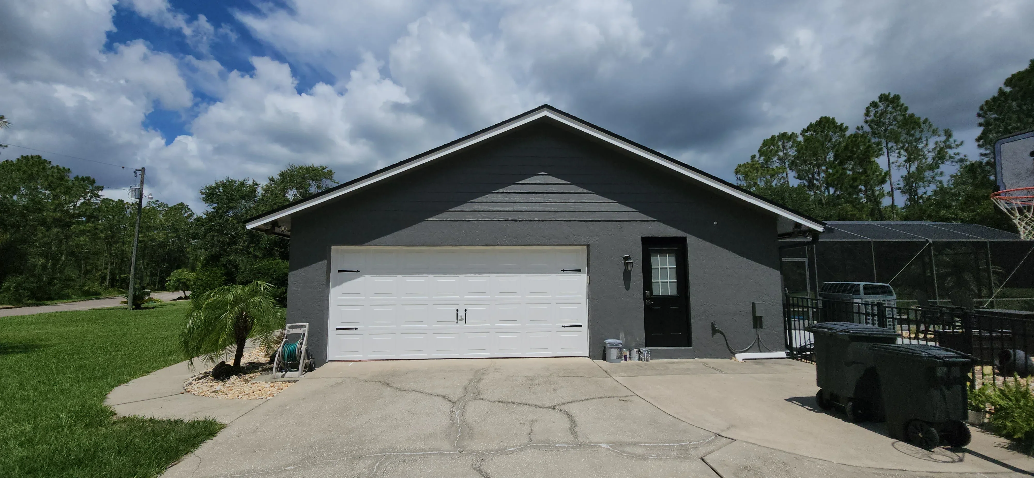Charcoal gray house with white garage door and trim, freshly painted exterior